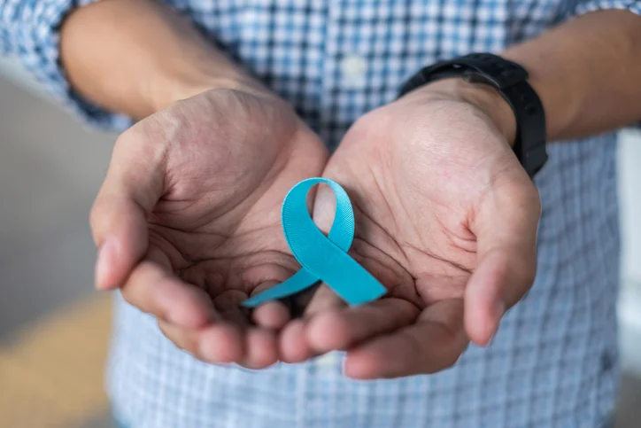 November Prostate Cancer Awareness month, Man in blue shirt with hand holding Blue Ribbon for supporting people living and illness. Healthcare, International men, Father and World cancer day concept