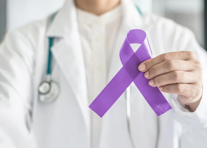 Orchid purple (lavender) ribbon awareness in doctor's hand for (all kinds cancers), Testicular Cancer awareness, Craniosynostosis, Epilepsy, Hodgkin's lymphoma, National Cancer Prevention Month